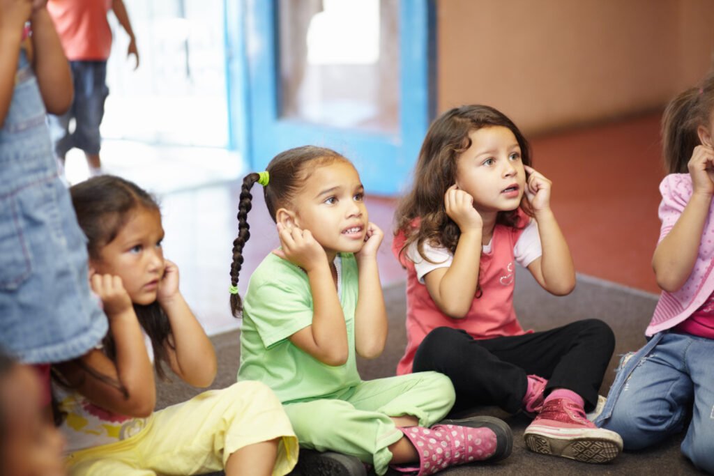 children covering their ears with concerned faces. 